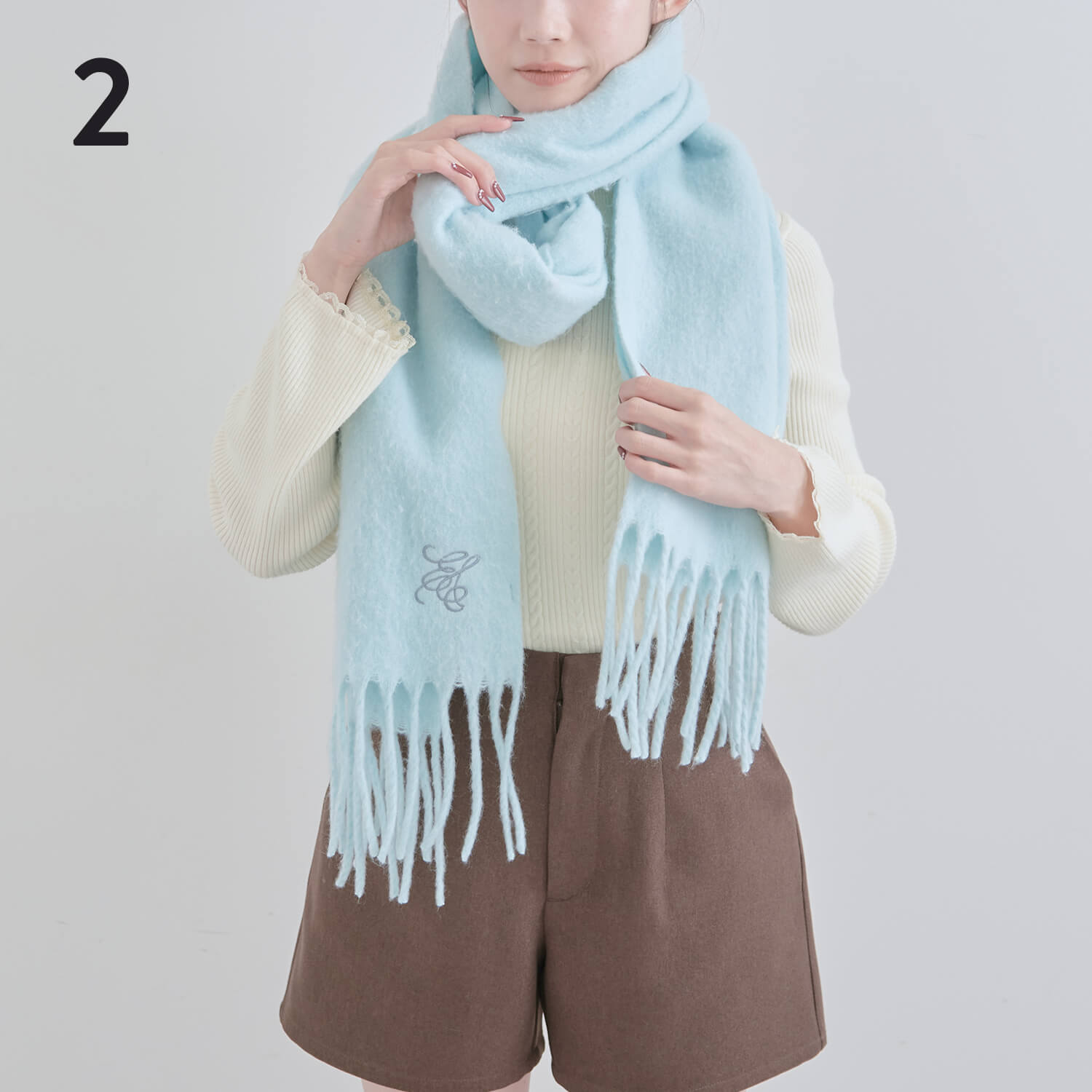 2）首の前の輪を少し引っぱり、ねじって輪っかを作る|マフラー巻き方