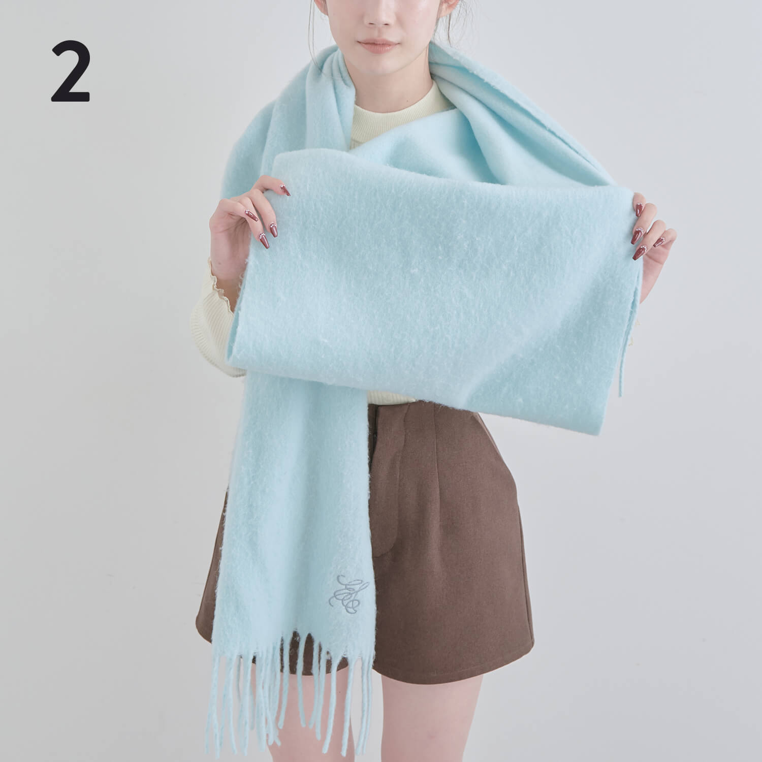 2）長い方の端を広げ、1～2回内側に折りたたむ＊この折りたたむ幅がリボンの横幅になる|マフラー巻き方