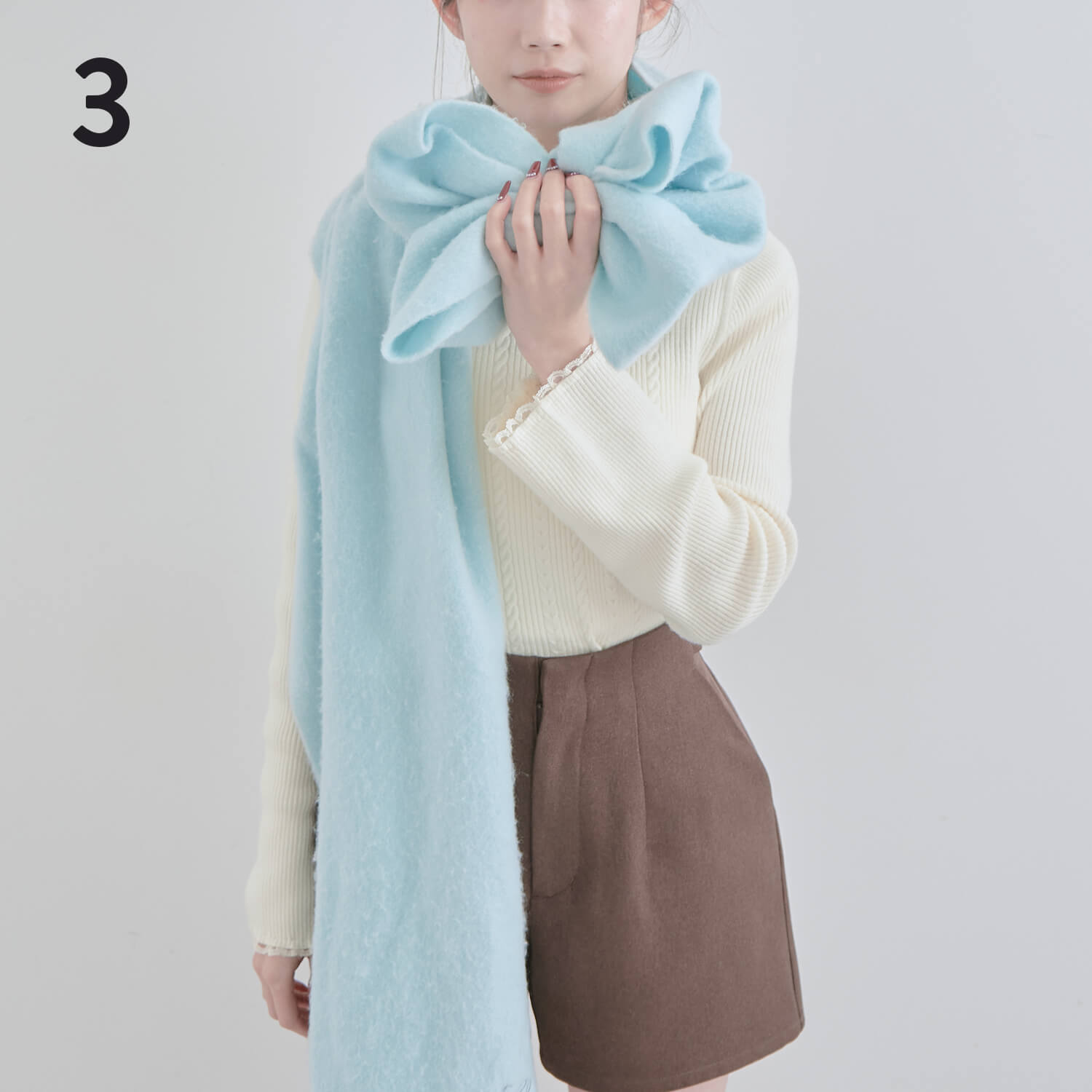 3）折りたたんだ部分を両端からまとめ片手でつかむ|マフラー巻き方