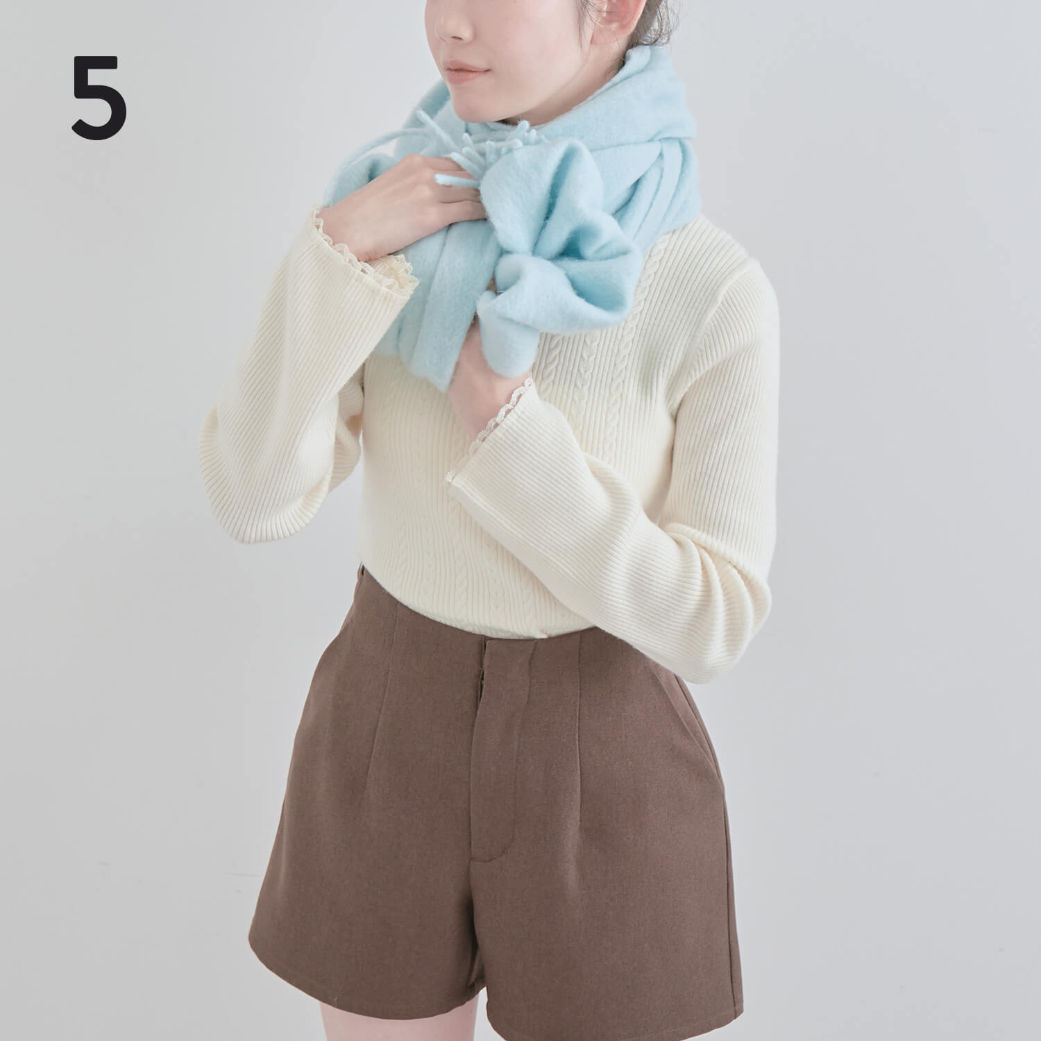 5）巻いた方をリボンの下から上にかぶせ、端を首元に入れ込む|マフラー巻き方